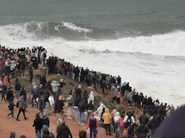 tourists watching giant waves in Nazaré on the road